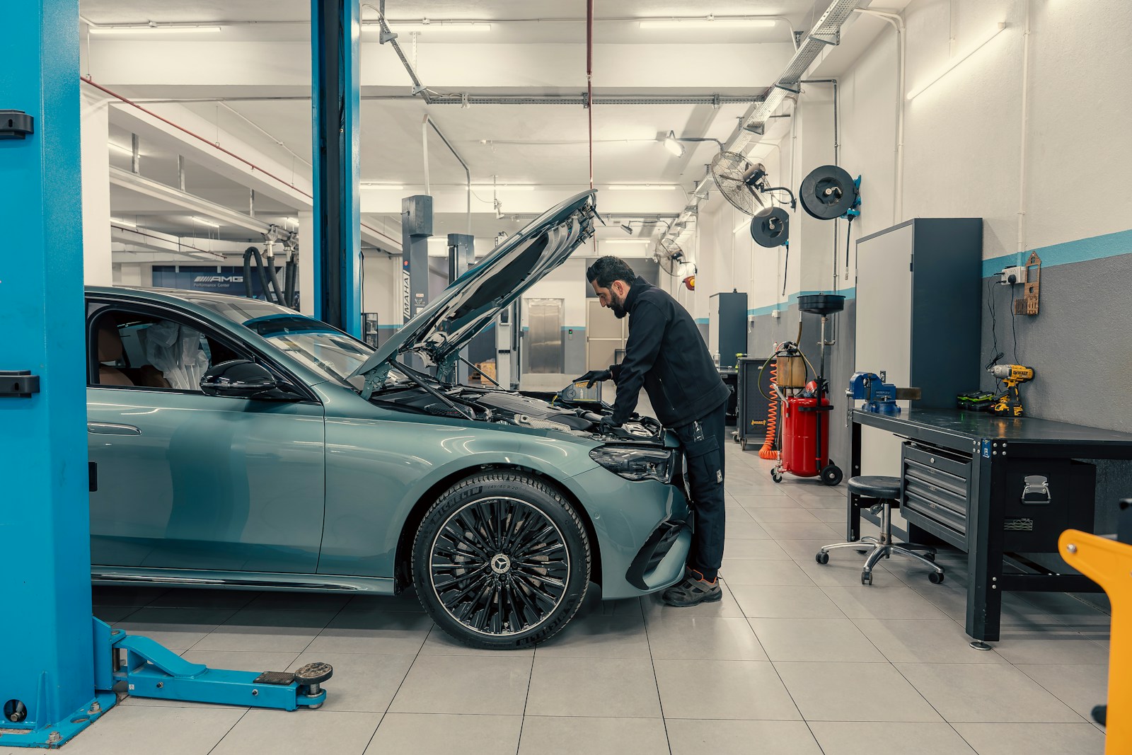 Mechanic servicing a luxury car in a clean professional garage